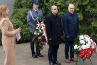 Wiceprezydent miasta Żory i przedwodniczący rady miasta, w tle zastępca komendanta miejskiego policji w Żorach przed pomnikiem ofiar zbrodni katyńskiej