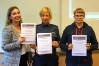 Wiktoria Kałus - studentka, policjantka i uczennica prezentują podpisane deklaracje bezpiecznego kierowcy