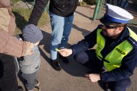 Policjant wręcza dziecku odblask