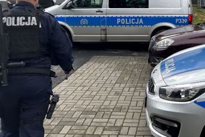 Na zdjęciu widać policjanta na terenie parkingu żorskiej Policji oraz policyjne radiowozy.